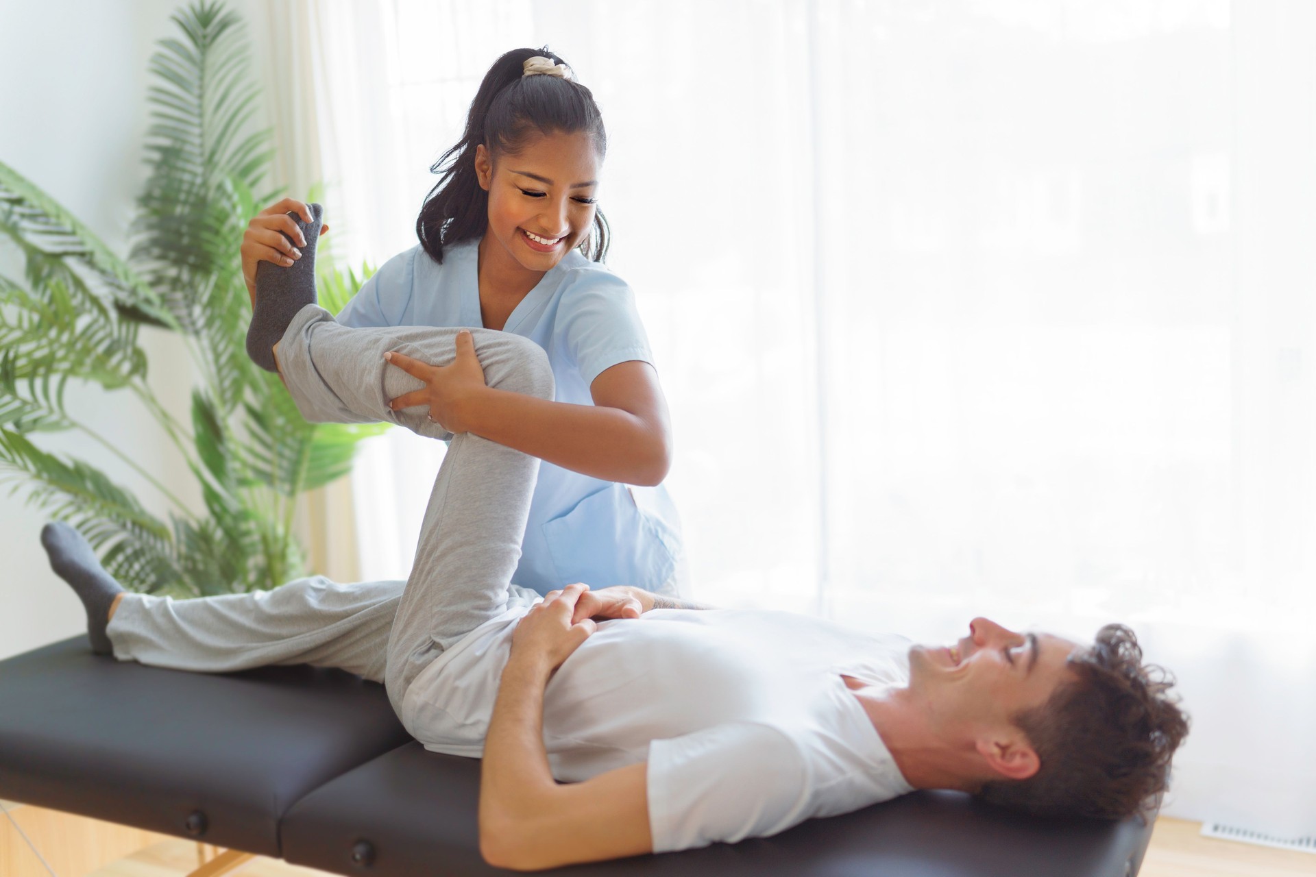 Young woman physiotherapist at physio clinic with customer