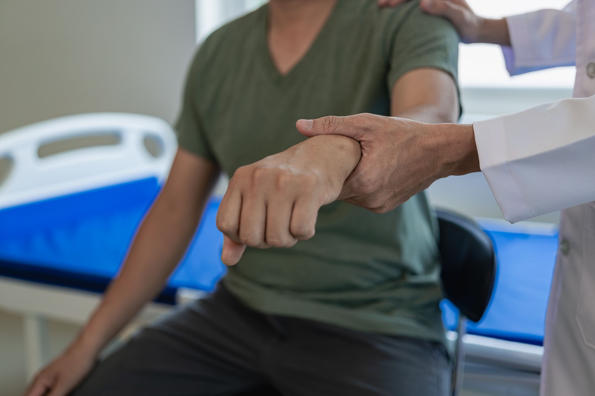 Doctors, physiotherapists treat patients with rehabilitation arm pain, do physiotherapy by treating his therapist in stretching in the clinic. Remote Picture