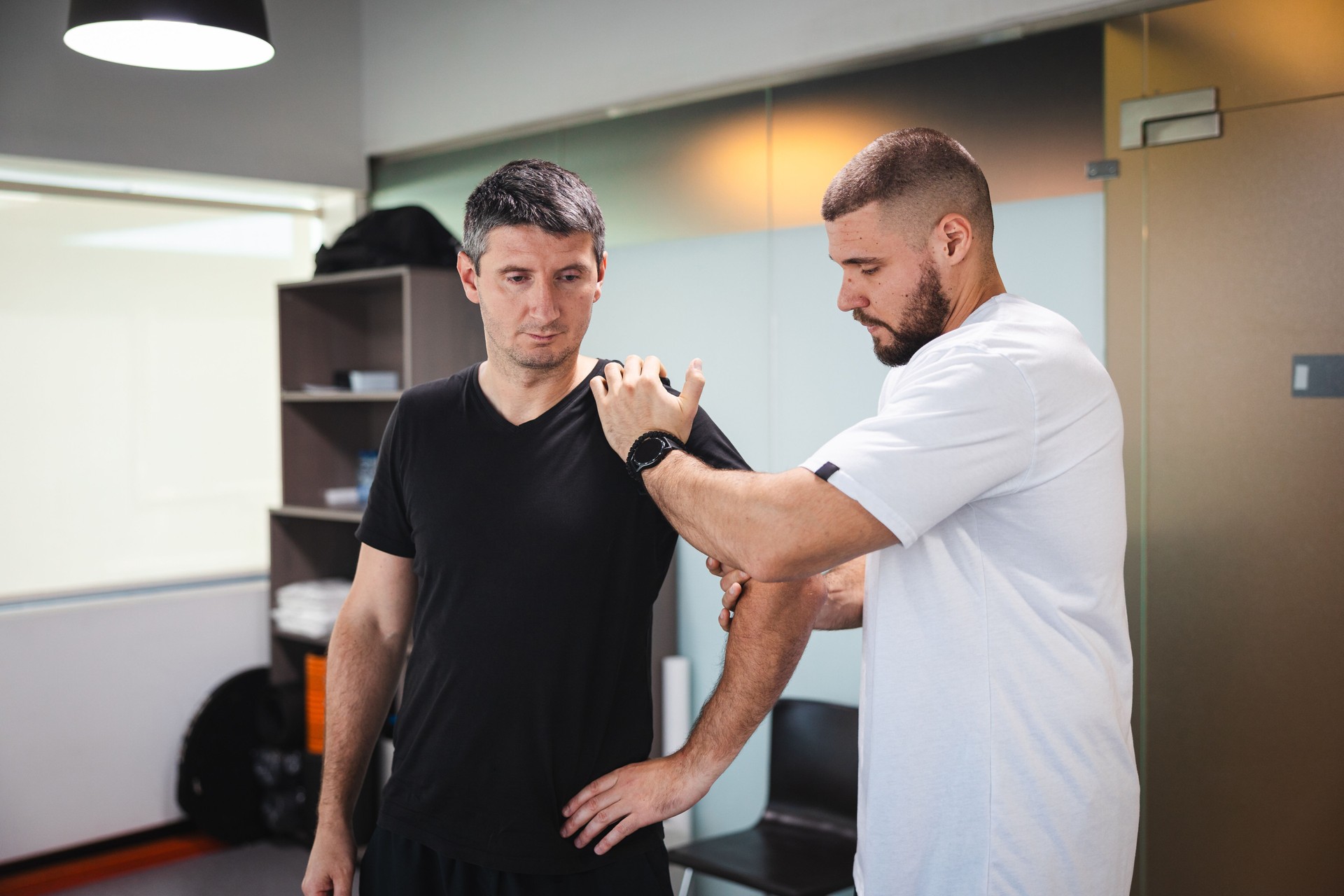 Young man getting stretched by a professional masseur